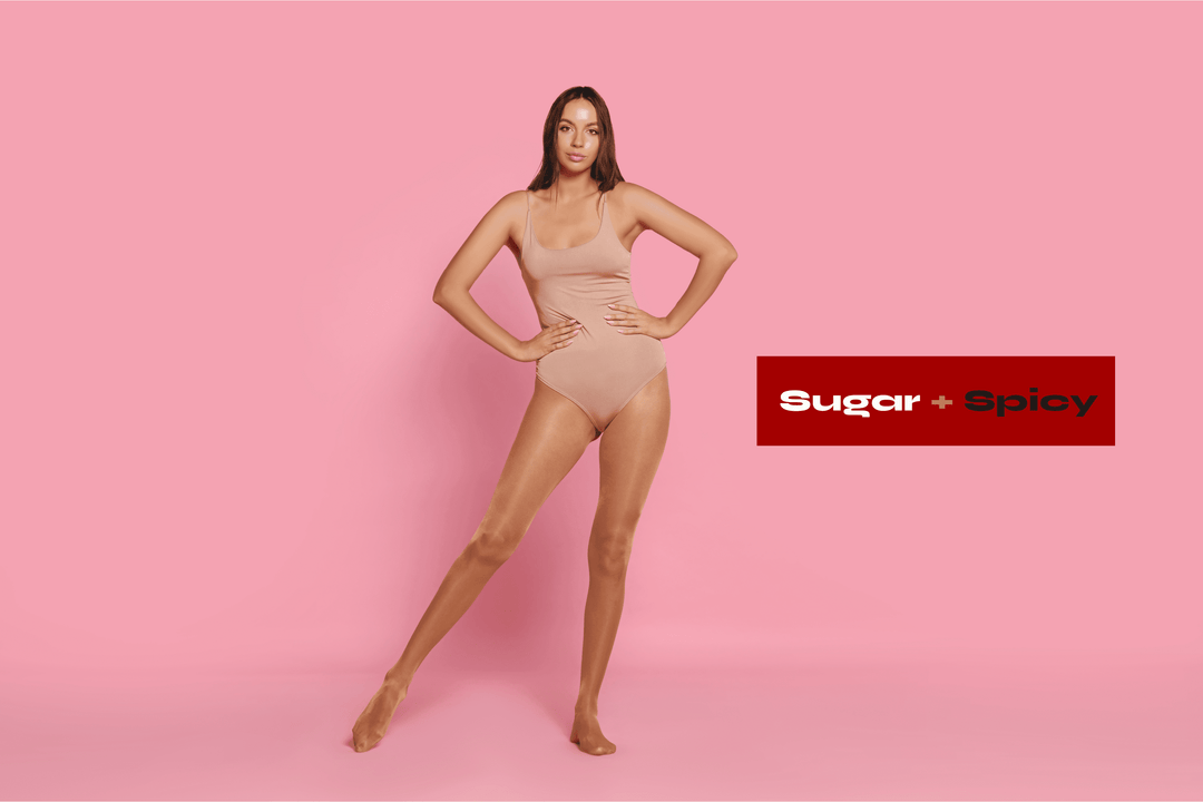 one-piece bodysuit model posing in nude seamless one-piece bodysuit on pink background