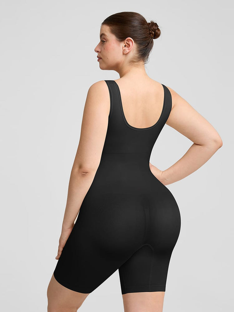 Person wearing a black bodysuit against a gray background
