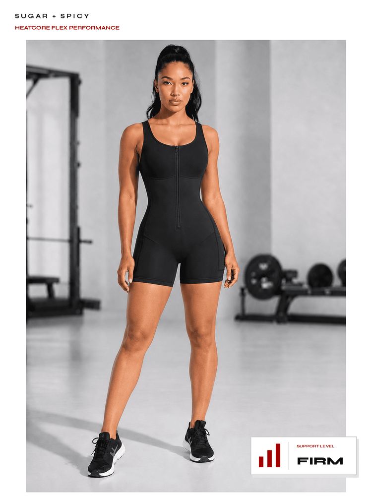 A woman modeling a black zip-front bodysuit in a gym setting, with text at the top reading 'SUGAR + SPICY' and a badge at the bottom right reading 'FIRM'.