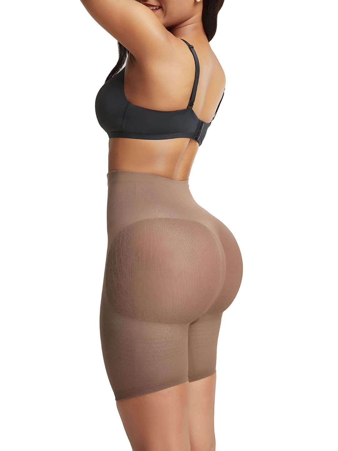 Woman wearing shapewear butt lifter shorts and black bra, side view against white background