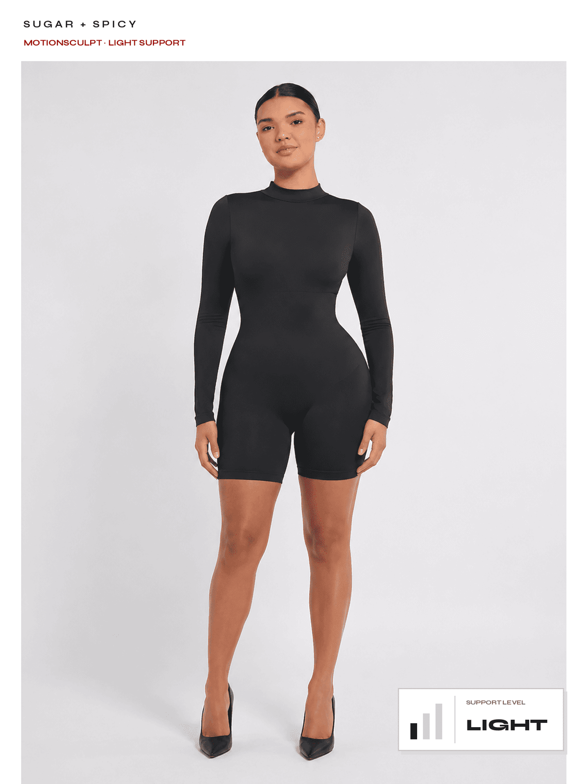 A model wearing a black long-sleeve biker shorts bodysuit with a mock neck, standing against a light gray studio background. Text at the top reads 'SUGAR + SPICY' and 'MOTIONSCULPT LIGHT SUPPORT', with a 'LIGHT SUPPORT LEVEL' graphic at the bottom right.