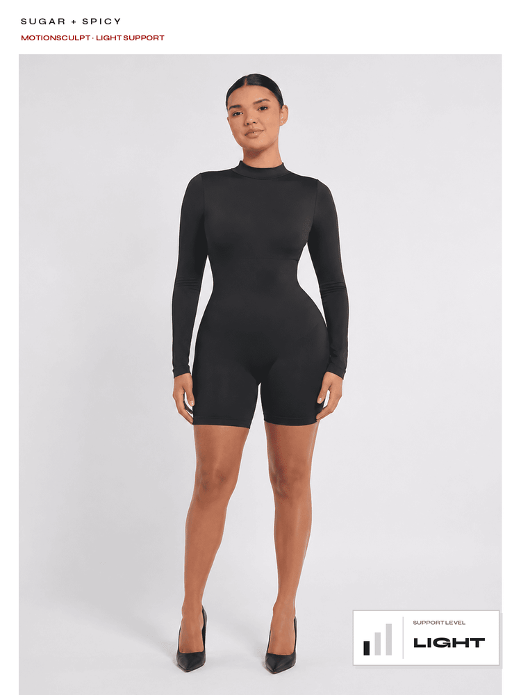 A model wearing a black long-sleeve biker shorts bodysuit with a mock neck, standing against a light gray studio background. Text at the top reads 'SUGAR + SPICY' and 'MOTIONSCULPT LIGHT SUPPORT', with a 'LIGHT SUPPORT LEVEL' graphic at the bottom right.