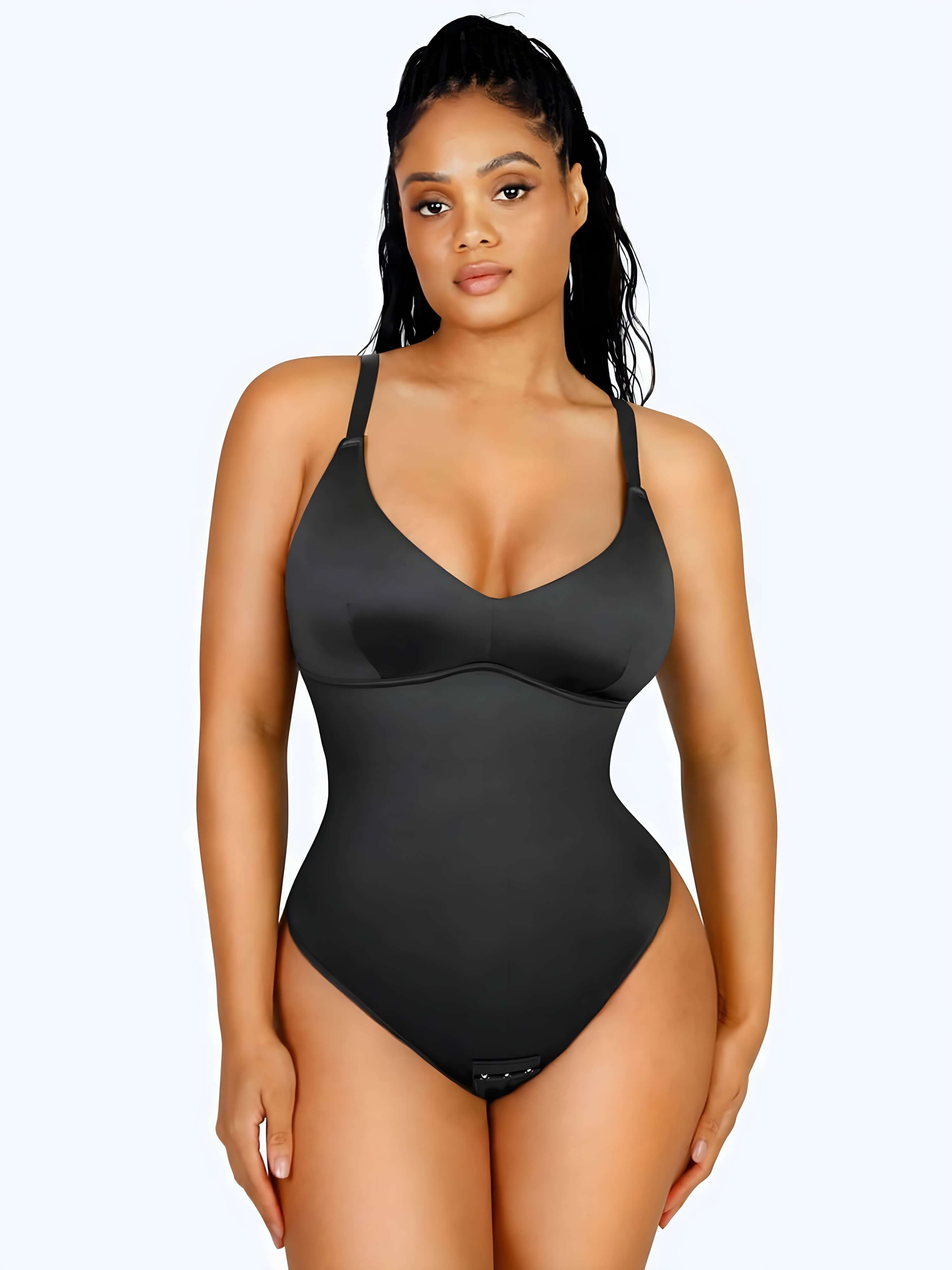 Woman wearing black shaping bodysuit lingerie against a white background, showcasing a sleek fitted silhouette