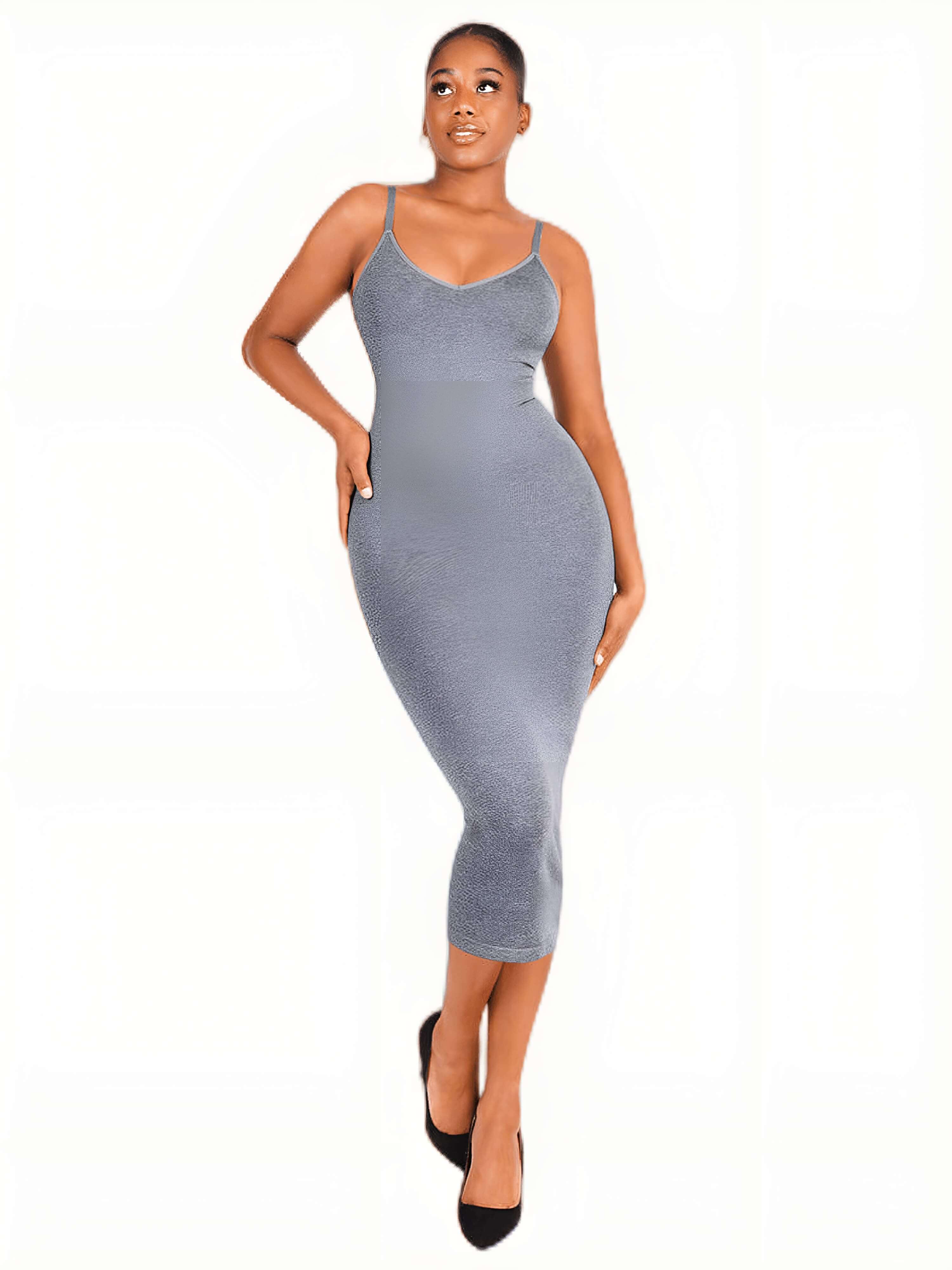 Woman wearing a fitted gray bodycon midi dress and black heels, posing against a white background