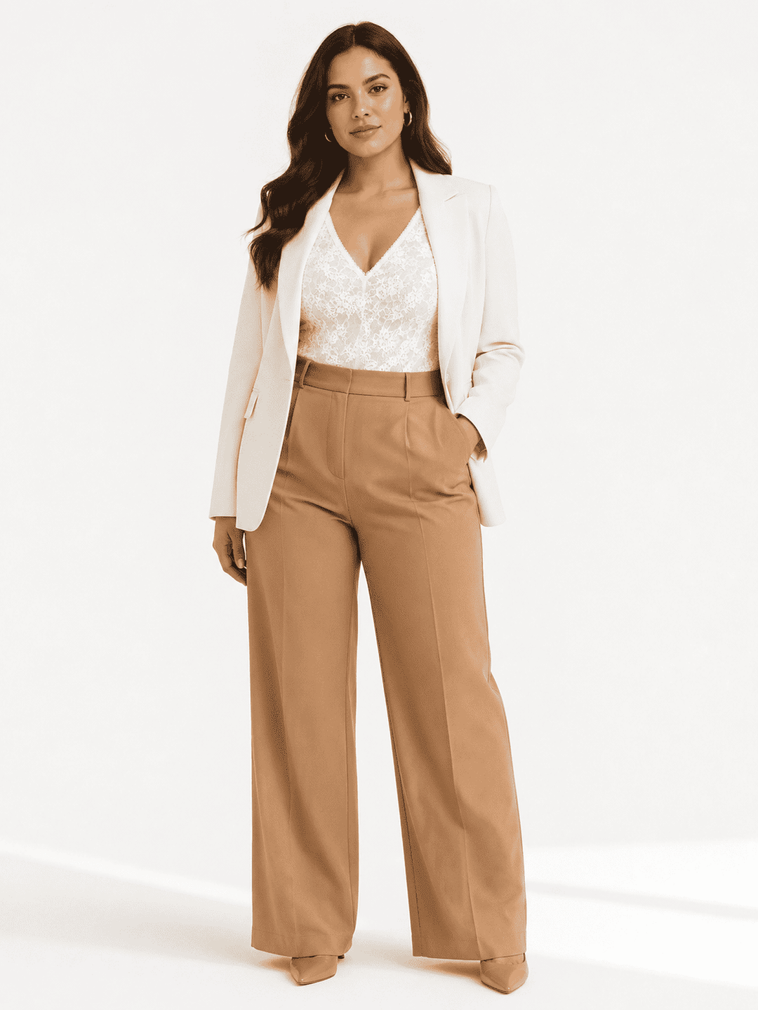A woman models a stylish outfit consisting of a white lace V-neck top, a white blazer, and high-waisted tan wide-leg trousers, set against a clean white studio background.