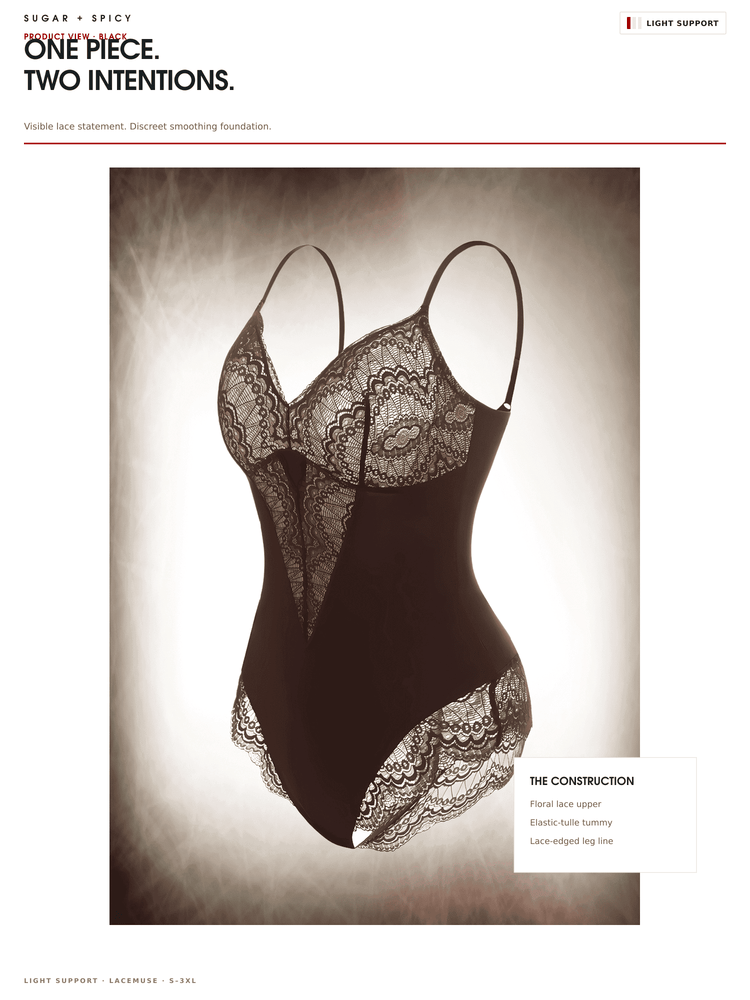 A lingerie bodysuit shown on a mannequin against a dramatic studio background. The garment is black with intricate sheer lace cups and lace trim at the waist and hips.