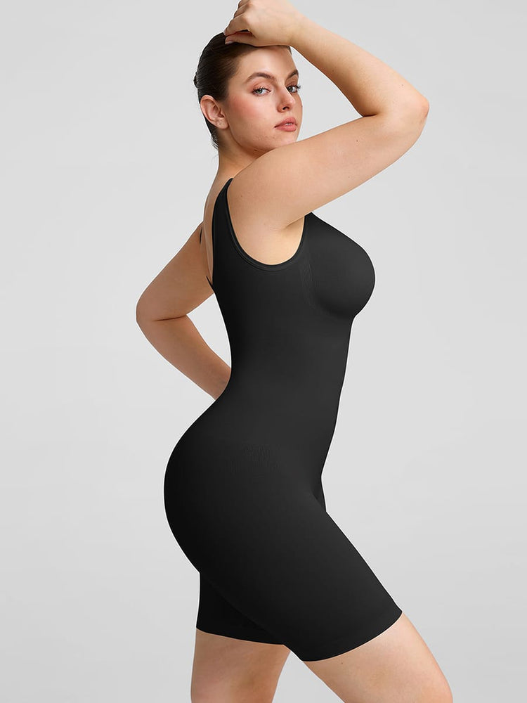 Woman wearing a black shapewear dress against a gray background