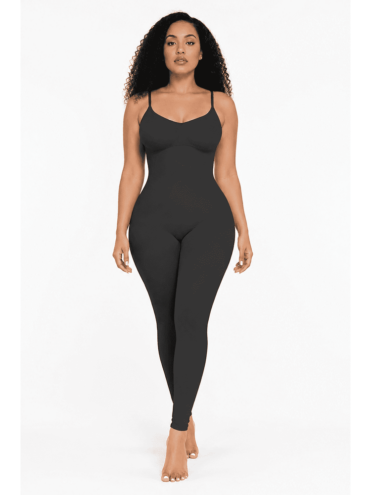 A woman modeling a black shapewear bodysuit with spaghetti straps and a scoop neckline, shown against a plain white studio background.