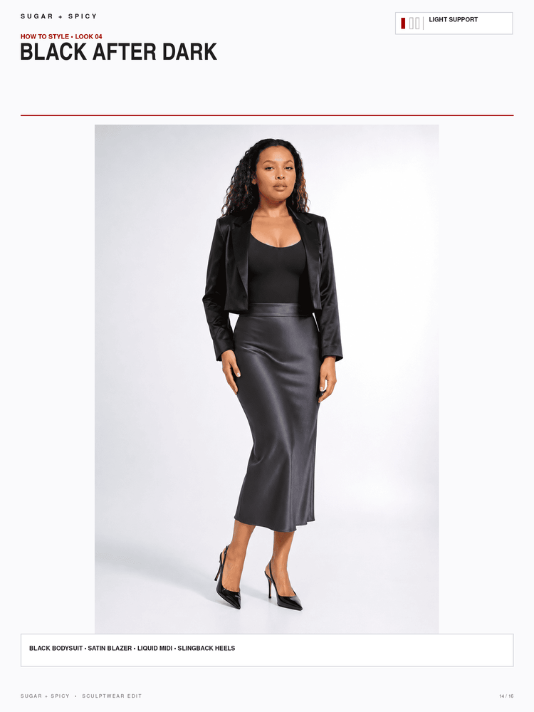 A model is shown wearing a black satin blazer, black bodysuit, and a black satin midi skirt against a light gray studio background. The image is presented as a catalog page with text headers reading 'BLACK AFTER DARK' and 'SUGAR + SPICY'.