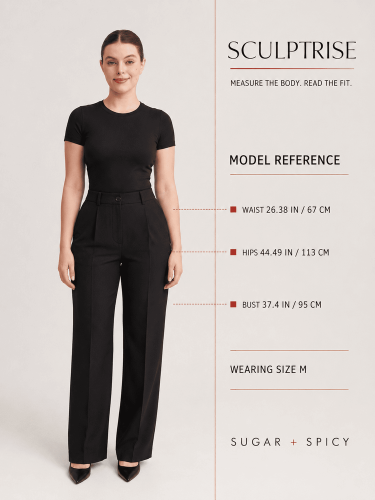A model wearing black high-waisted cropped trousers and a black short-sleeve top stands against a light beige studio background, with measurement callouts and text for the SCULPTRISE fit guide by SUGAR + SPICY.