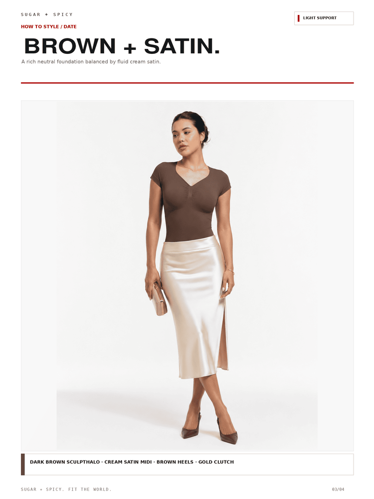 A fashion editorial page showing a model wearing a dark brown short-sleeve V-neck top and a cream satin midi skirt against a white background, with text reading 'BROWN + SATIN.' and product color notes.