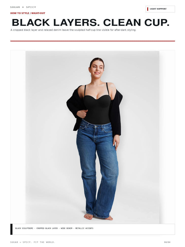 A model stands against a light gray studio background wearing a black cropped camisole, blue jeans, and a black cardigan draped off the shoulders. The image appears to be a fashion editorial or catalog page with text at the top reading 'BLACK LAYERS.