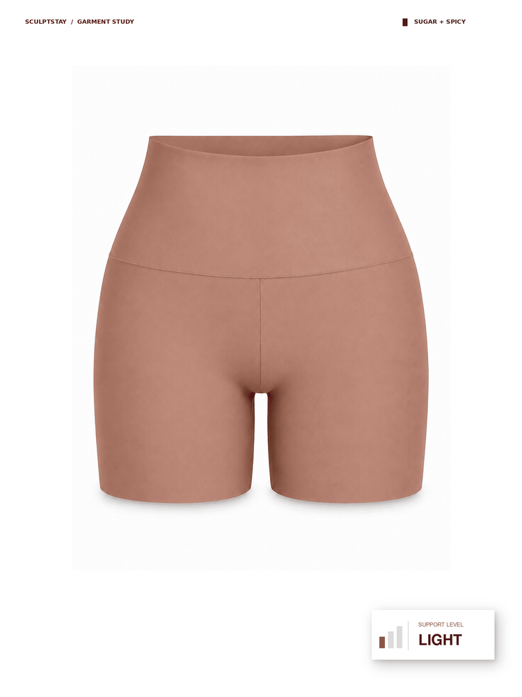 A pair of high-waisted, seamless athletic shorts in a dusty rose-beige color, presented on a clean white background with product information text overlays.