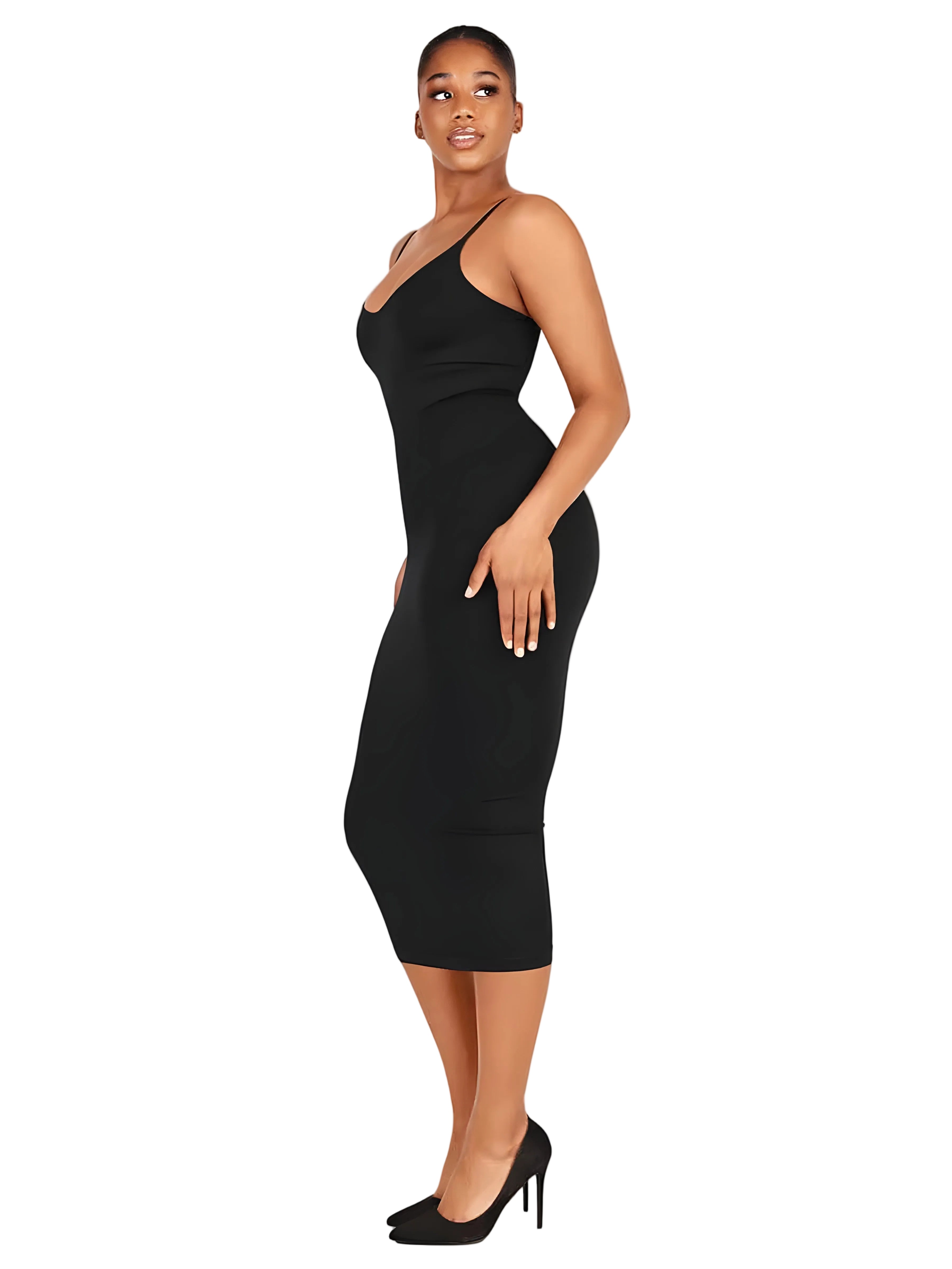A woman modeling a fitted black spaghetti-strap midi dress with a plunging neckline, shown in profile against a solid light gray studio background.