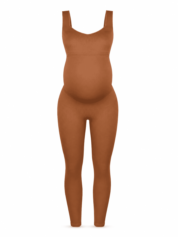A full-body view of a person wearing a form-fitting, sleeveless, full-length bodysuit or shapewear in a warm rust brown color, shown against a plain white background.