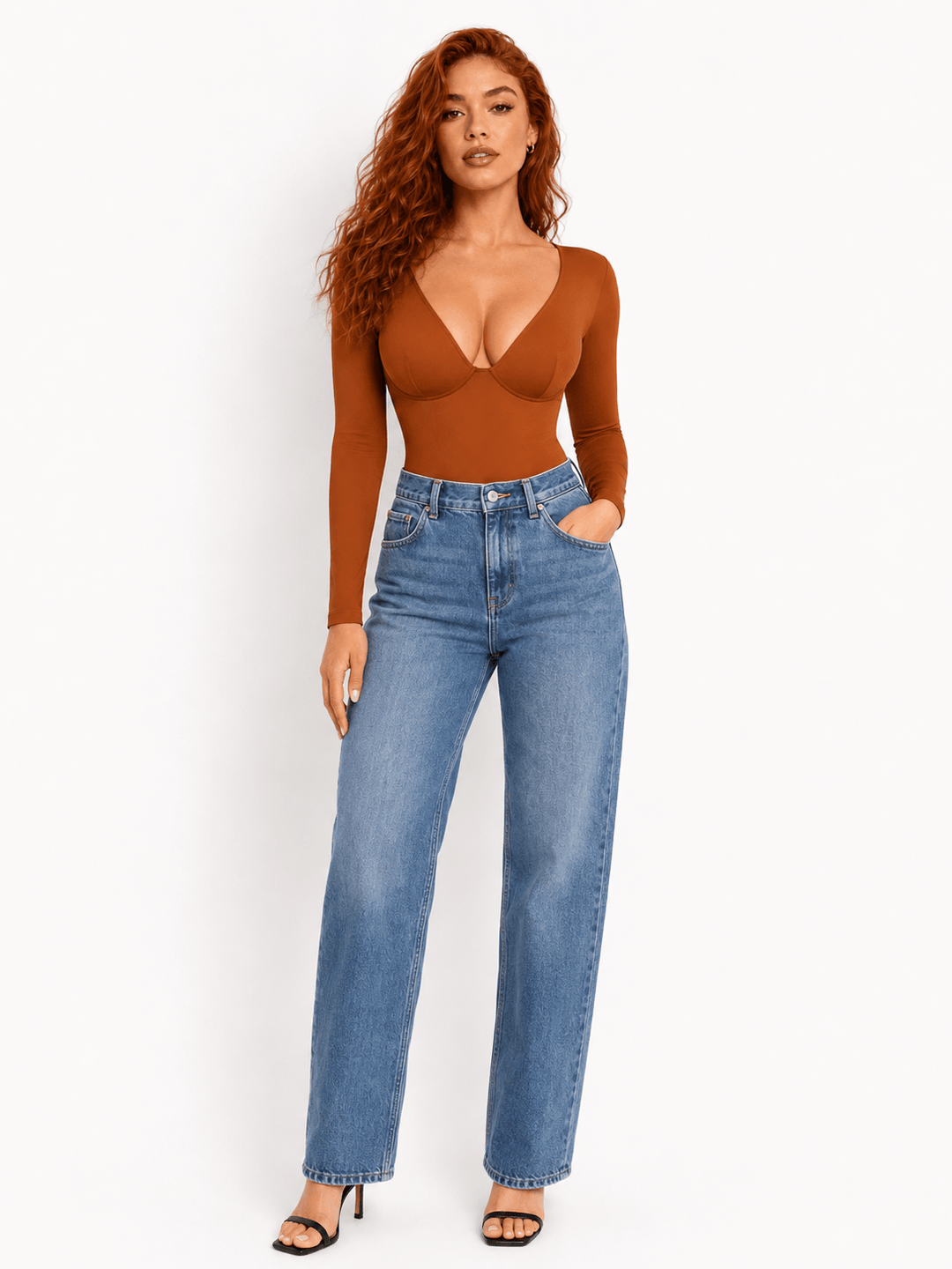 Model wearing an Ultra Deep Sculpt Long Sleeve Bodysuit with deep V-neck bodysuit and high-waisted jeans.