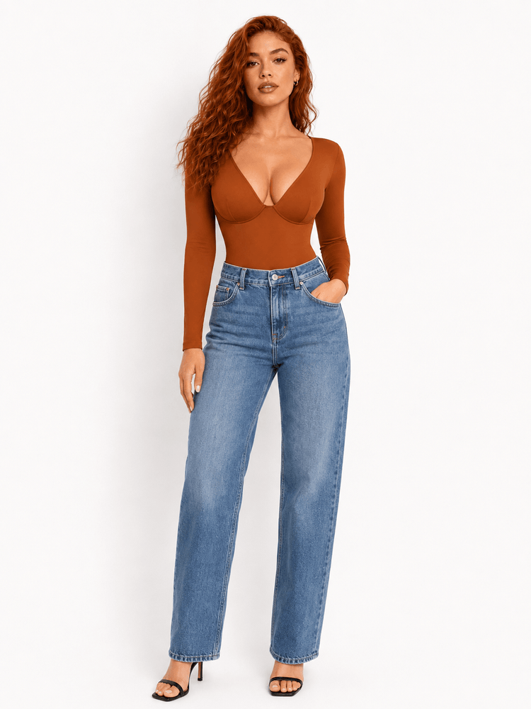 Model wearing an Ultra Deep Sculpt Long Sleeve Bodysuit with deep V-neck bodysuit and high-waisted jeans.