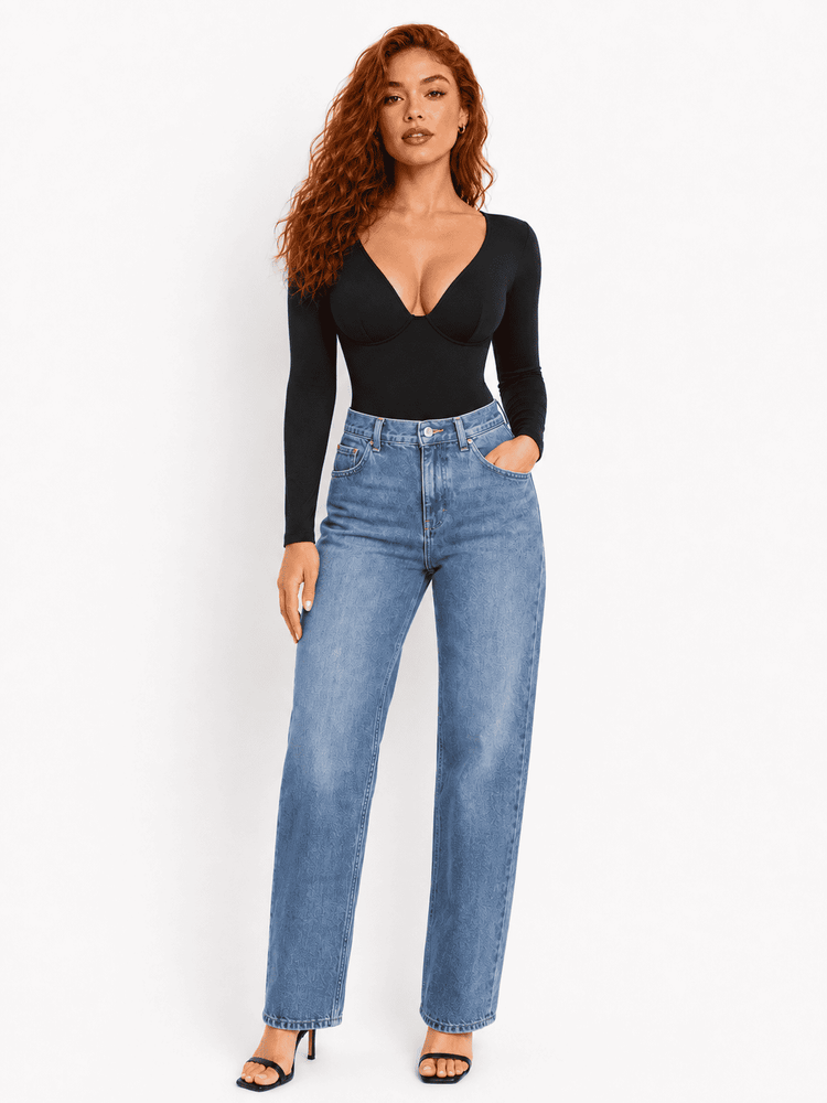 Model wearing a deep V-neck bodysuit, styled with high-waisted jeans and heels, showcasing a fashionable look.
