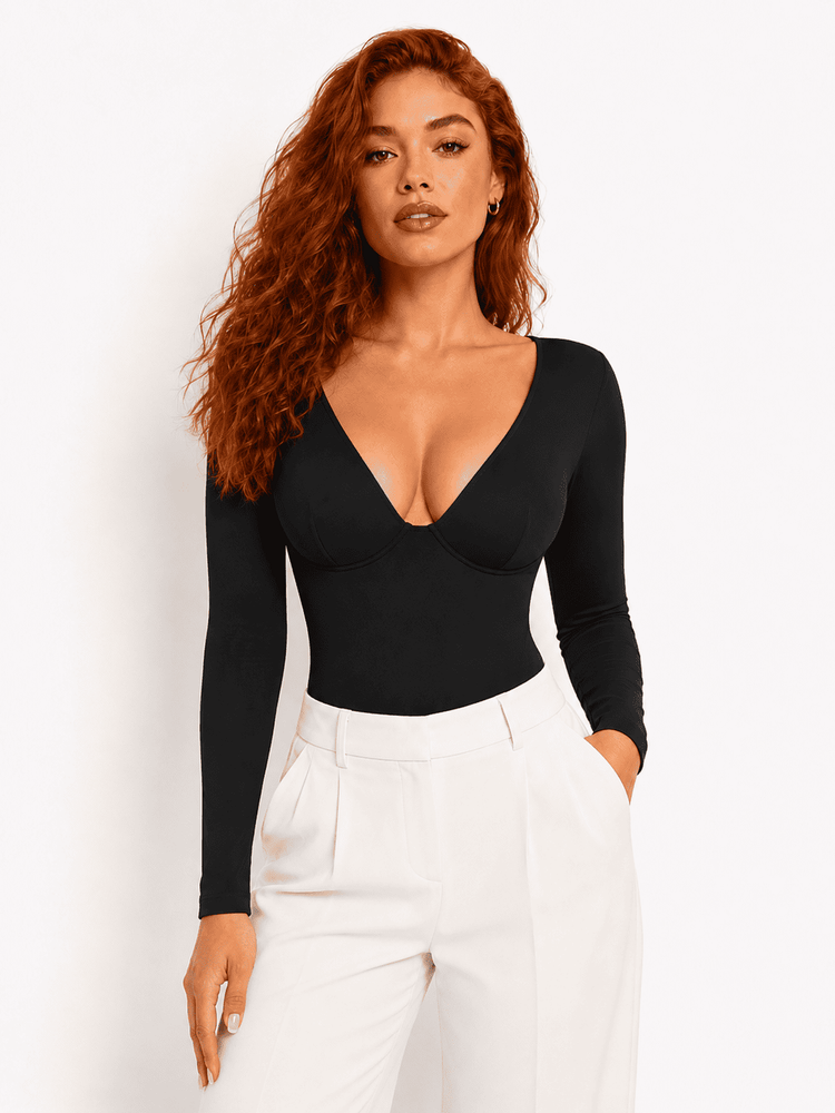 Model wearing a black deep V-neck bodysuit with long sleeves and high-waisted pants.