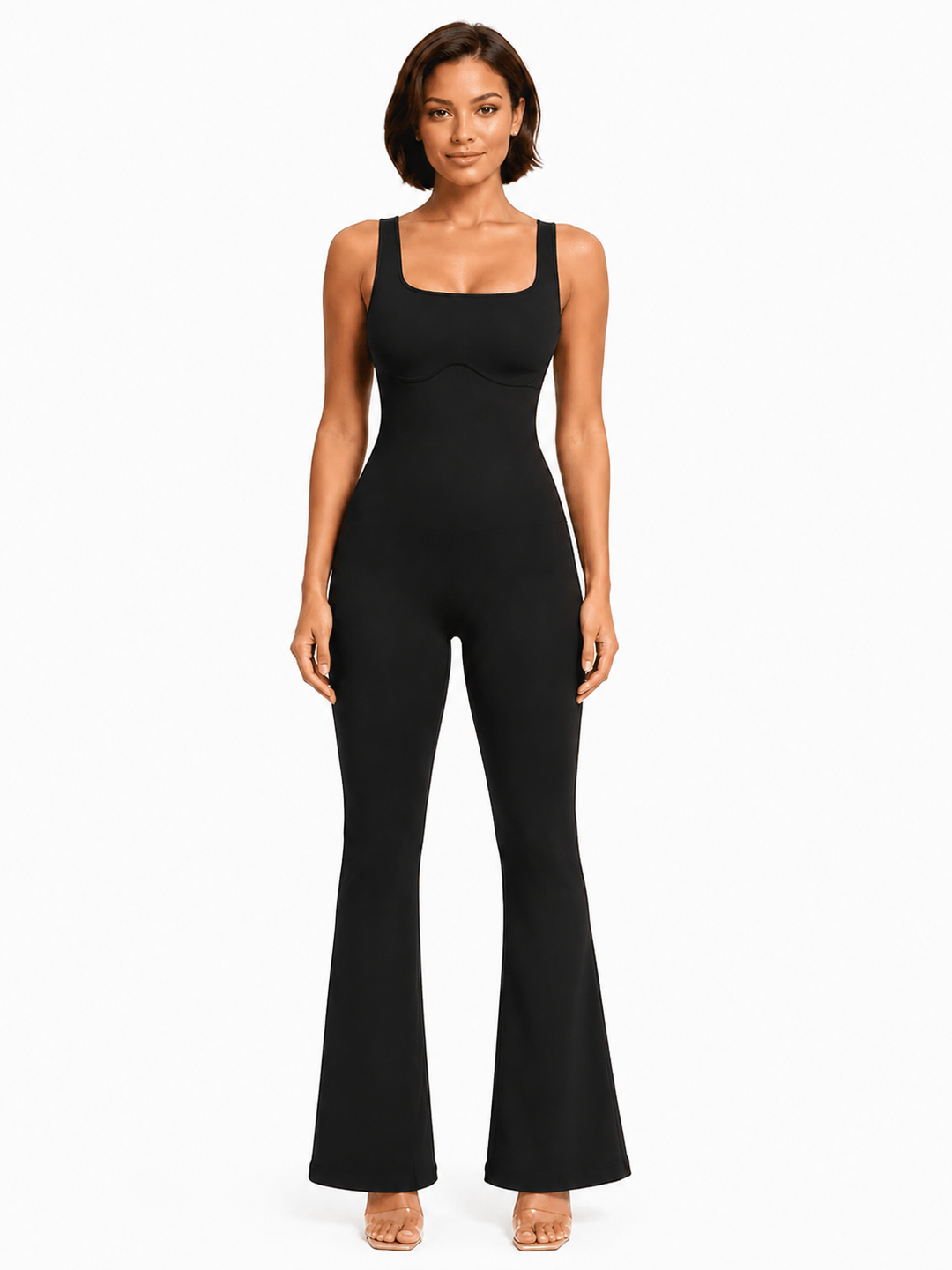 A woman modeling a black sleeveless jumpsuit with a square neckline and flared legs, standing against a plain white studio background.