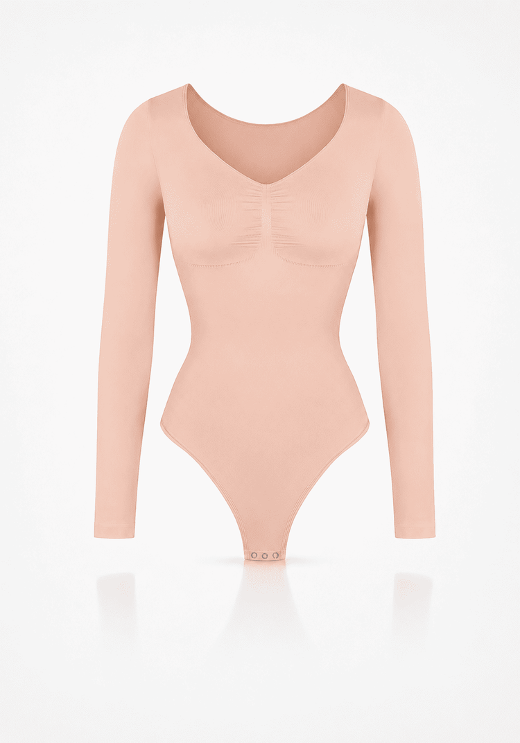 Sculpting long sleeve bodysuit in soft peach color with seamless design and light compression.