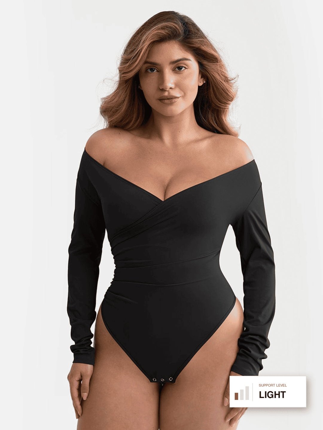 A woman modeling a black long-sleeve off-the-shoulder bodysuit against a plain light background. A small label in the bottom right corner reads 'SUPPORT LEVEL LIGHT'.
