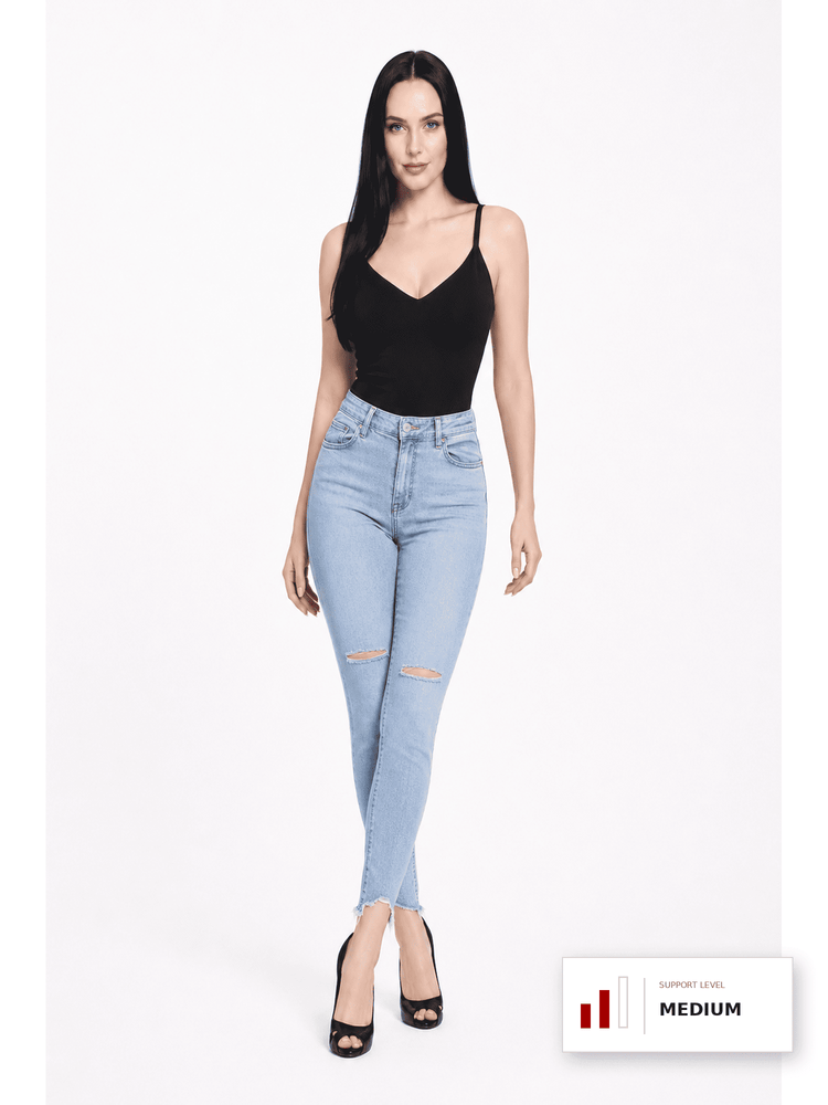 A woman modeling light-wash blue skinny jeans with distressed knee details, paired with a black camisole top and black heels, against a plain white studio background. A small support level graphic appears in the bottom right corner.