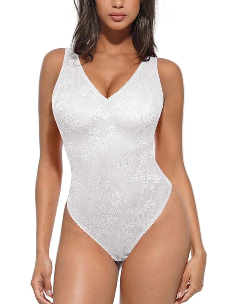 A woman modeling a white lace bodysuit with a V-neckline and sheer floral pattern against a light gray studio background.