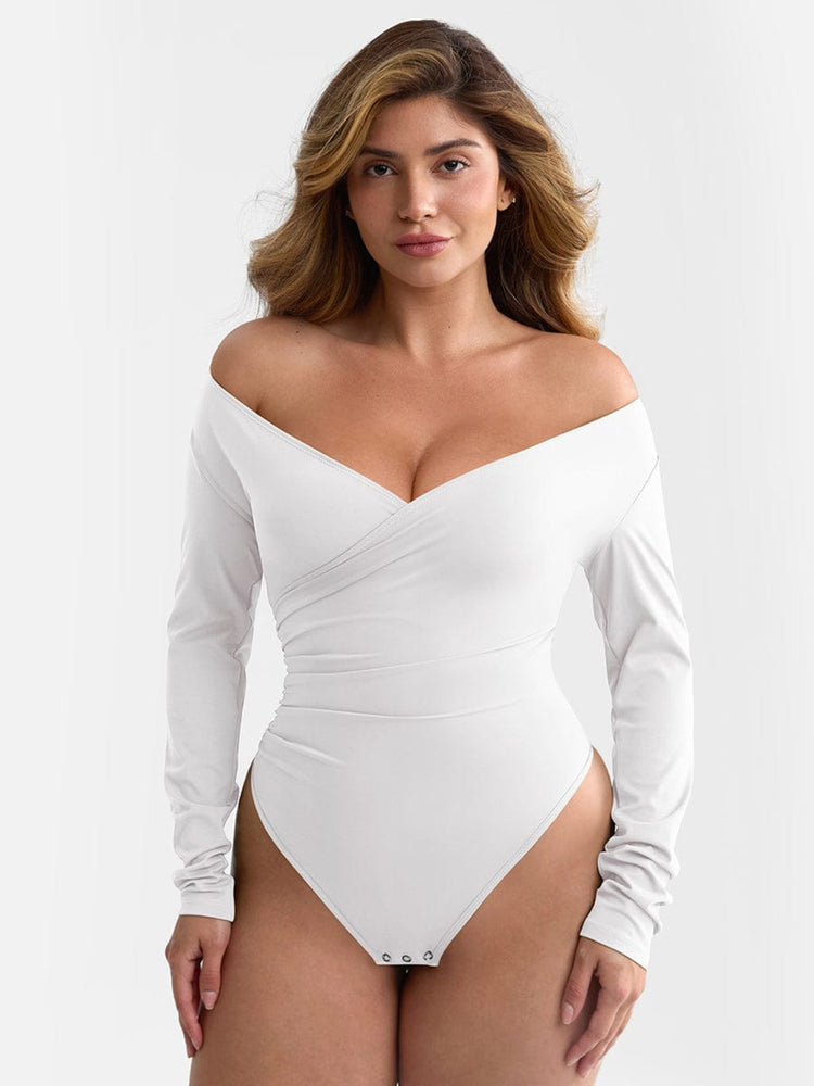 Woman wearing a white off-shoulder long-sleeve swimsuit against a plain background