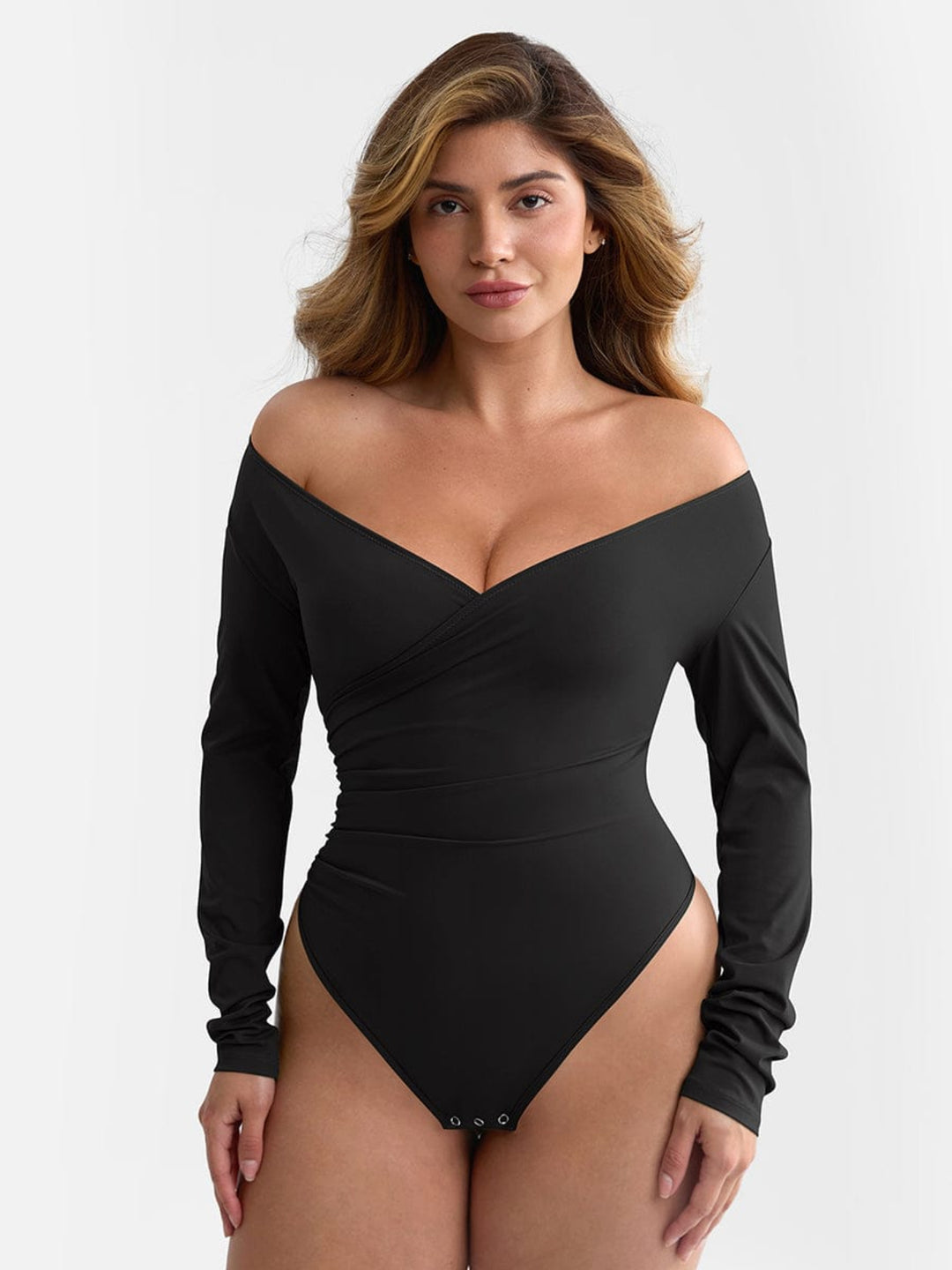 Woman wearing a black off-shoulder bodysuit against a white background