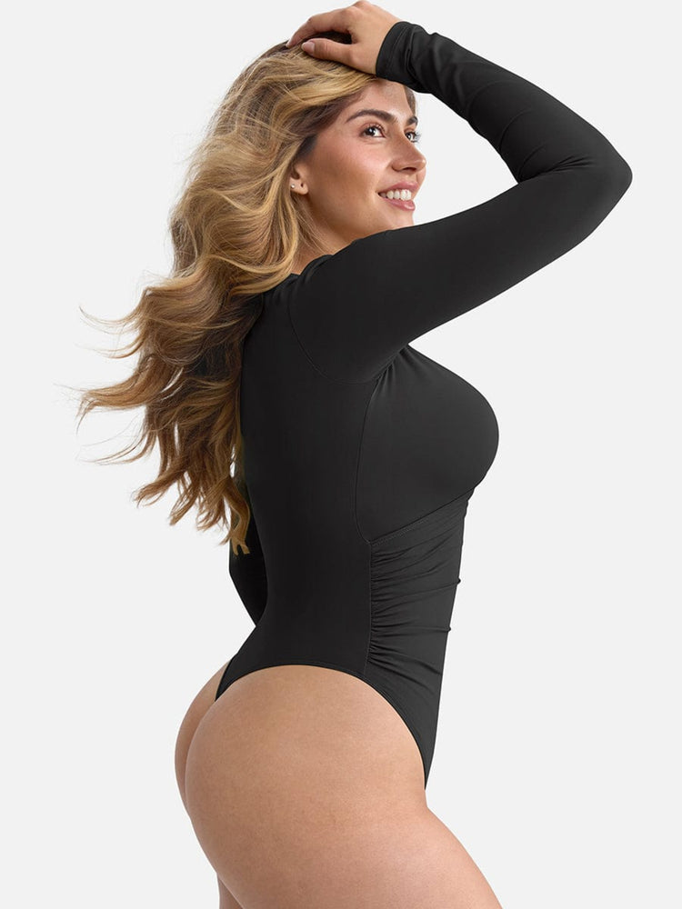 Woman wearing a black bodysuit against a plain background