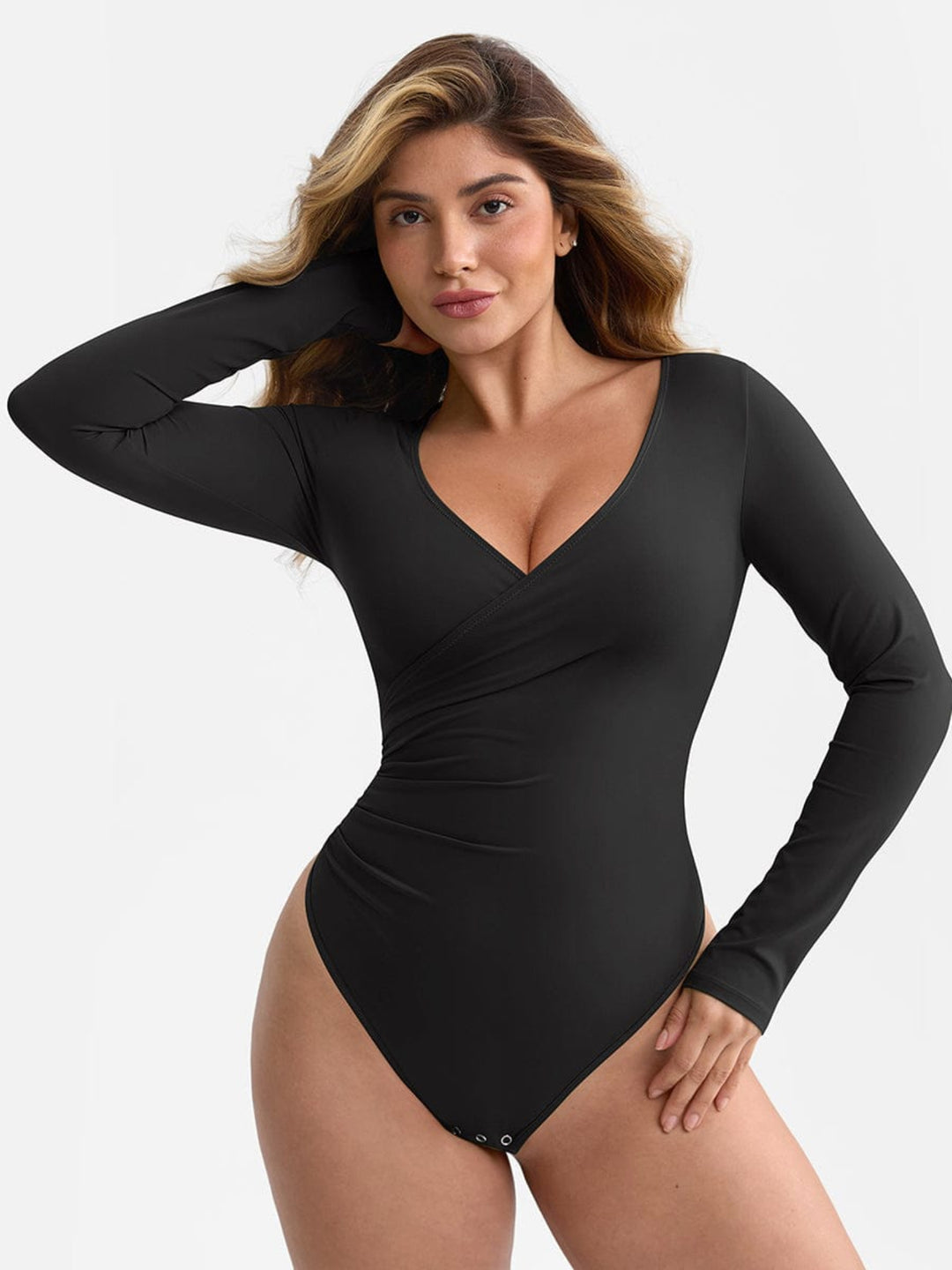 Woman wearing a black bodysuit against a plain background