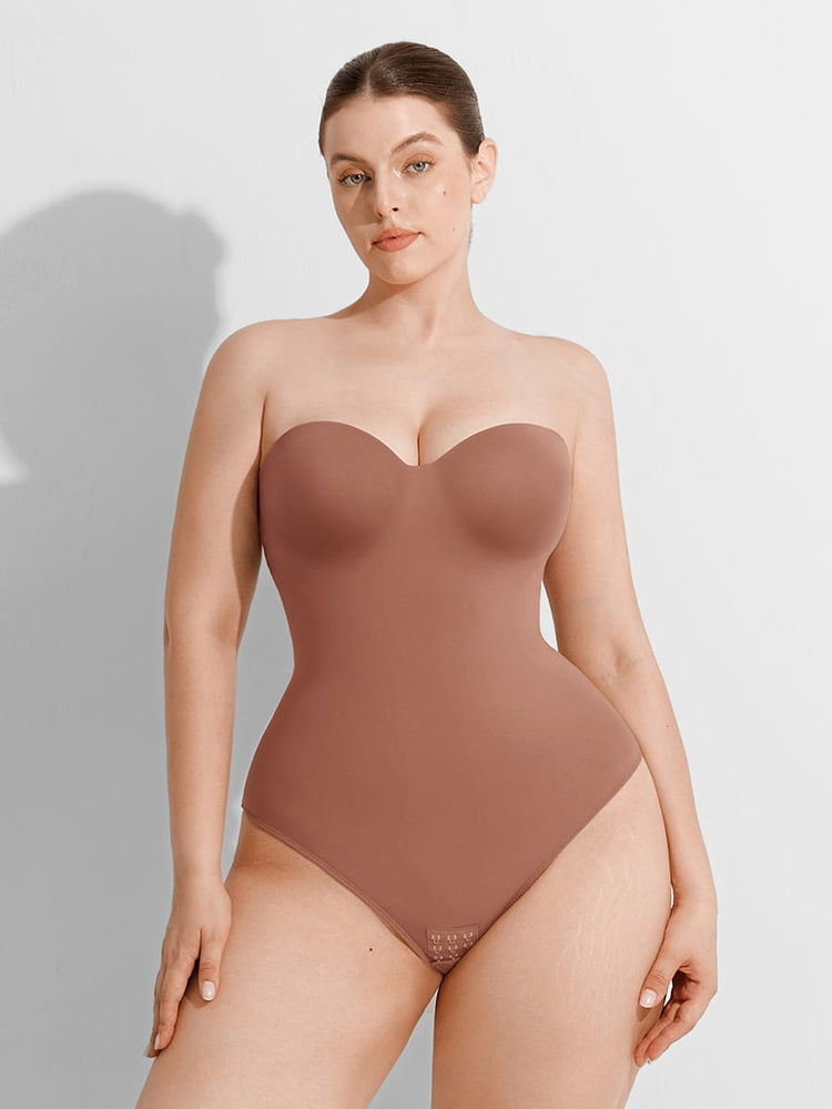Woman wearing a brown strapless bodysuit against a plain background