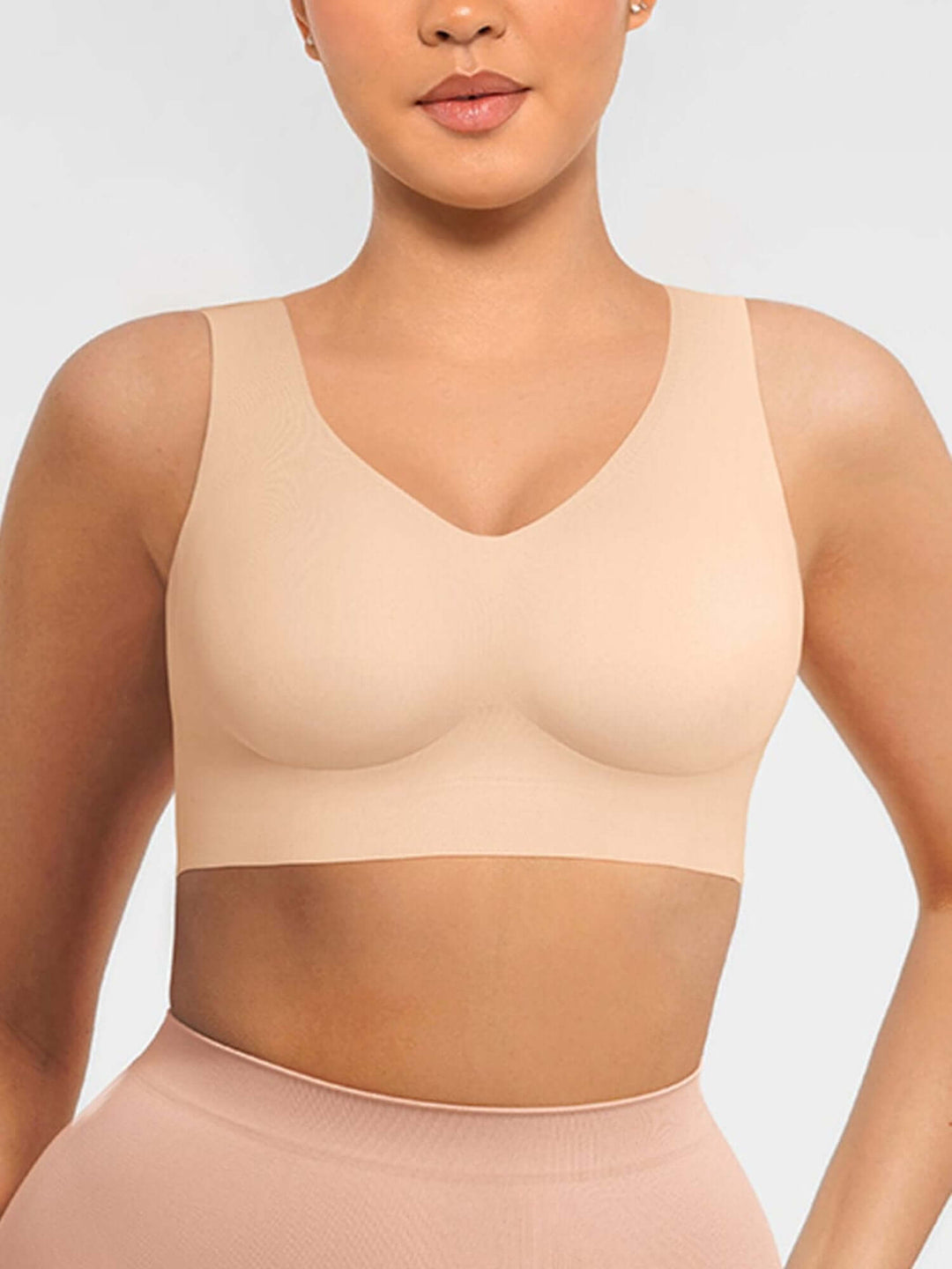 Beige compression garment worn by a model on a plain background