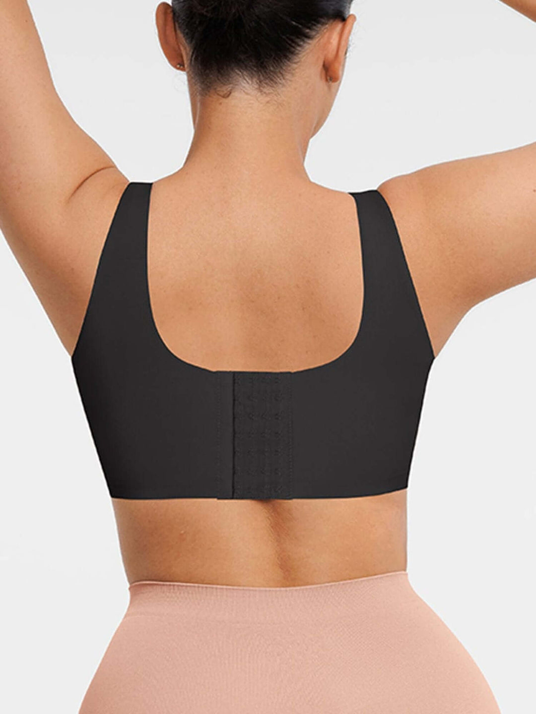 Black sports bra worn by a person on a light gray background