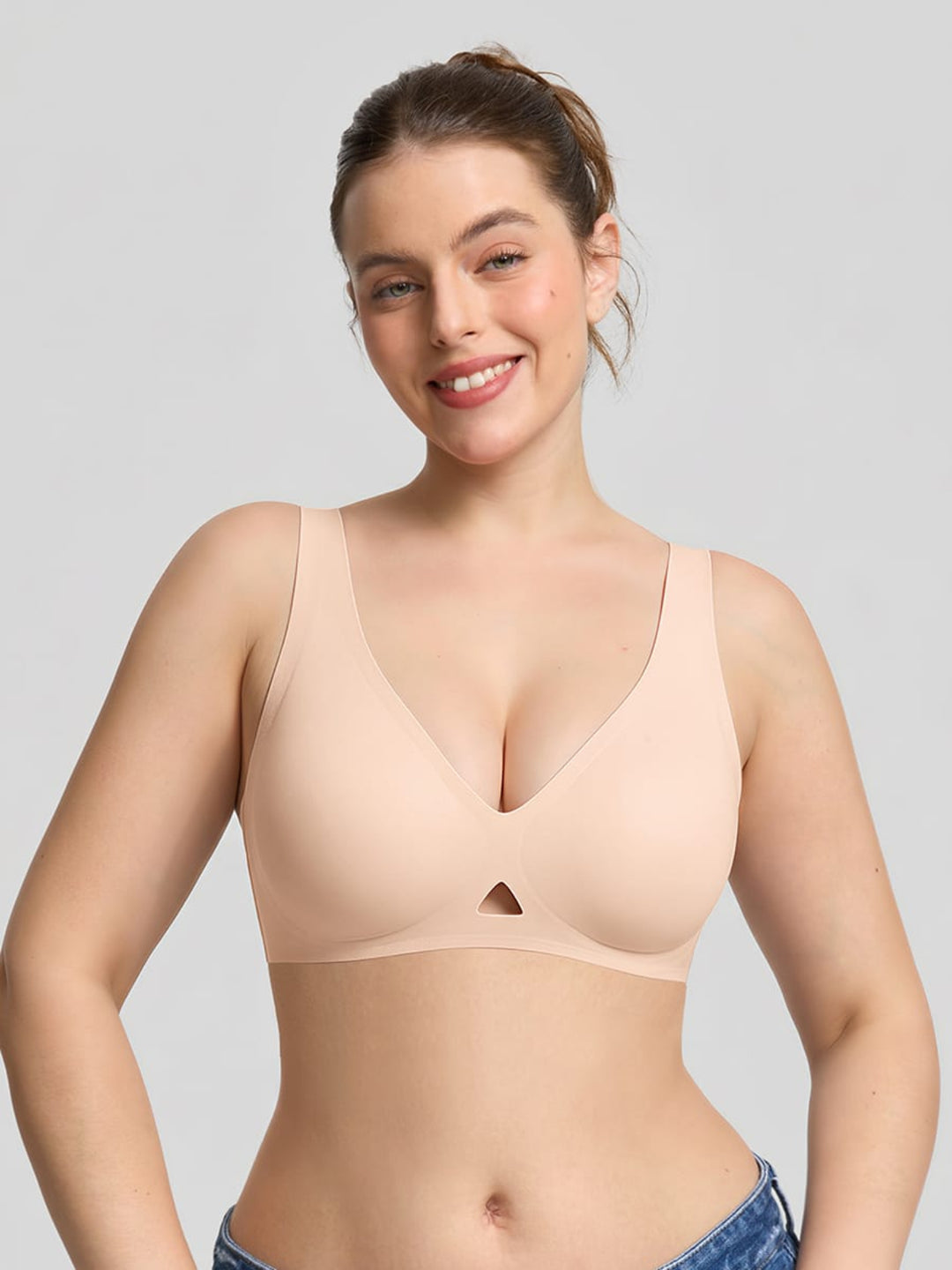 Woman wearing a beige bra against a plain background