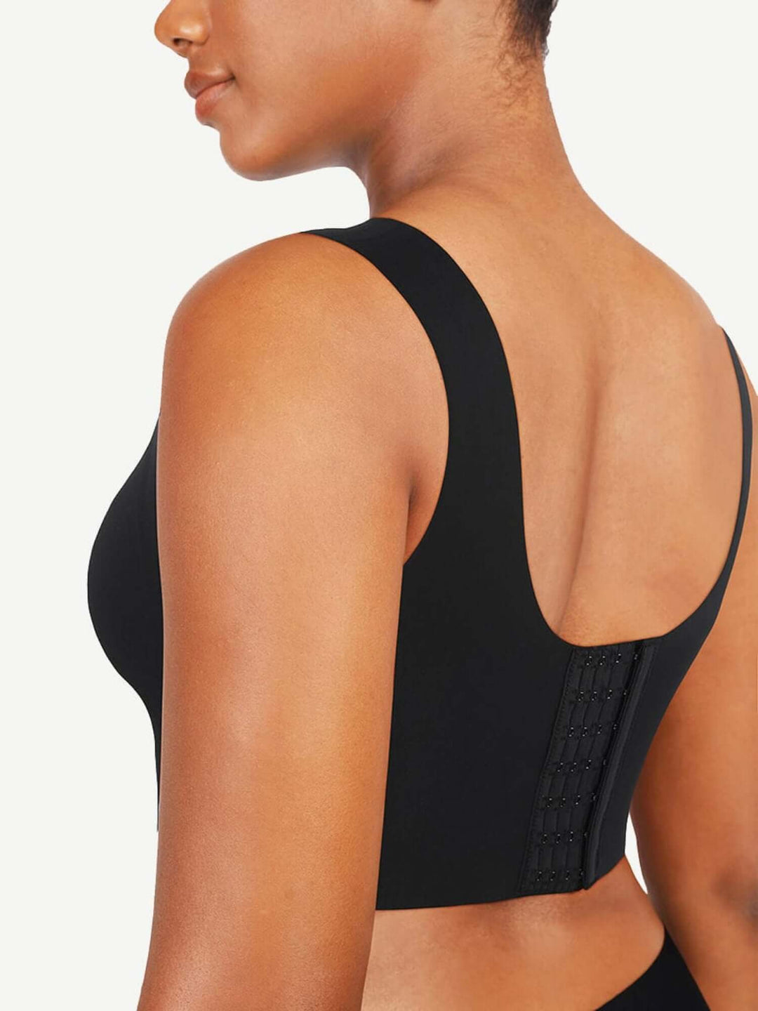 Black sports bra worn by a person on a plain background