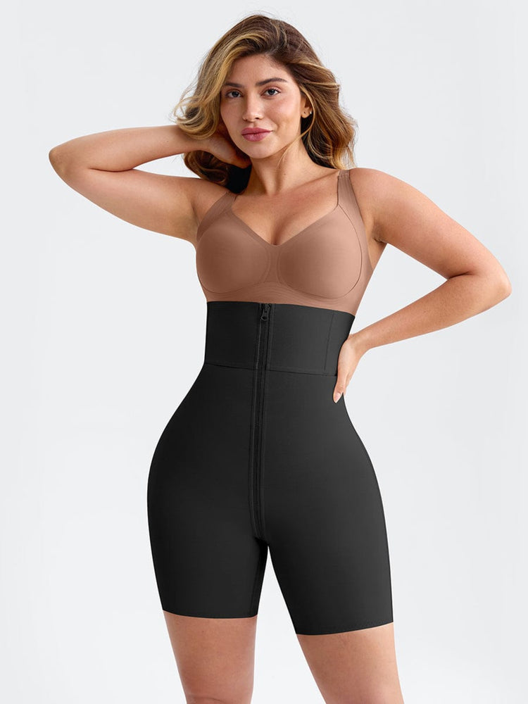 Woman wearing a black shapewear romper with a beige bralette on a light gray background
