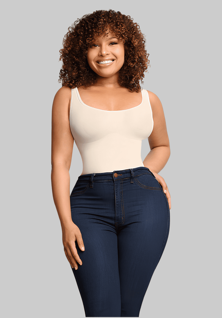 Smiling woman wearing compression sculpt brief bodysuit under dark jeans for a smooth, curve-enhancing silhouette