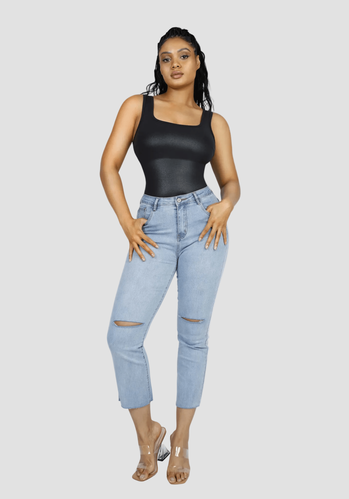 faux leather bodysuit with square neckline styled with light blue jeans and clear heels, polished glossy finish for day-to-night wear