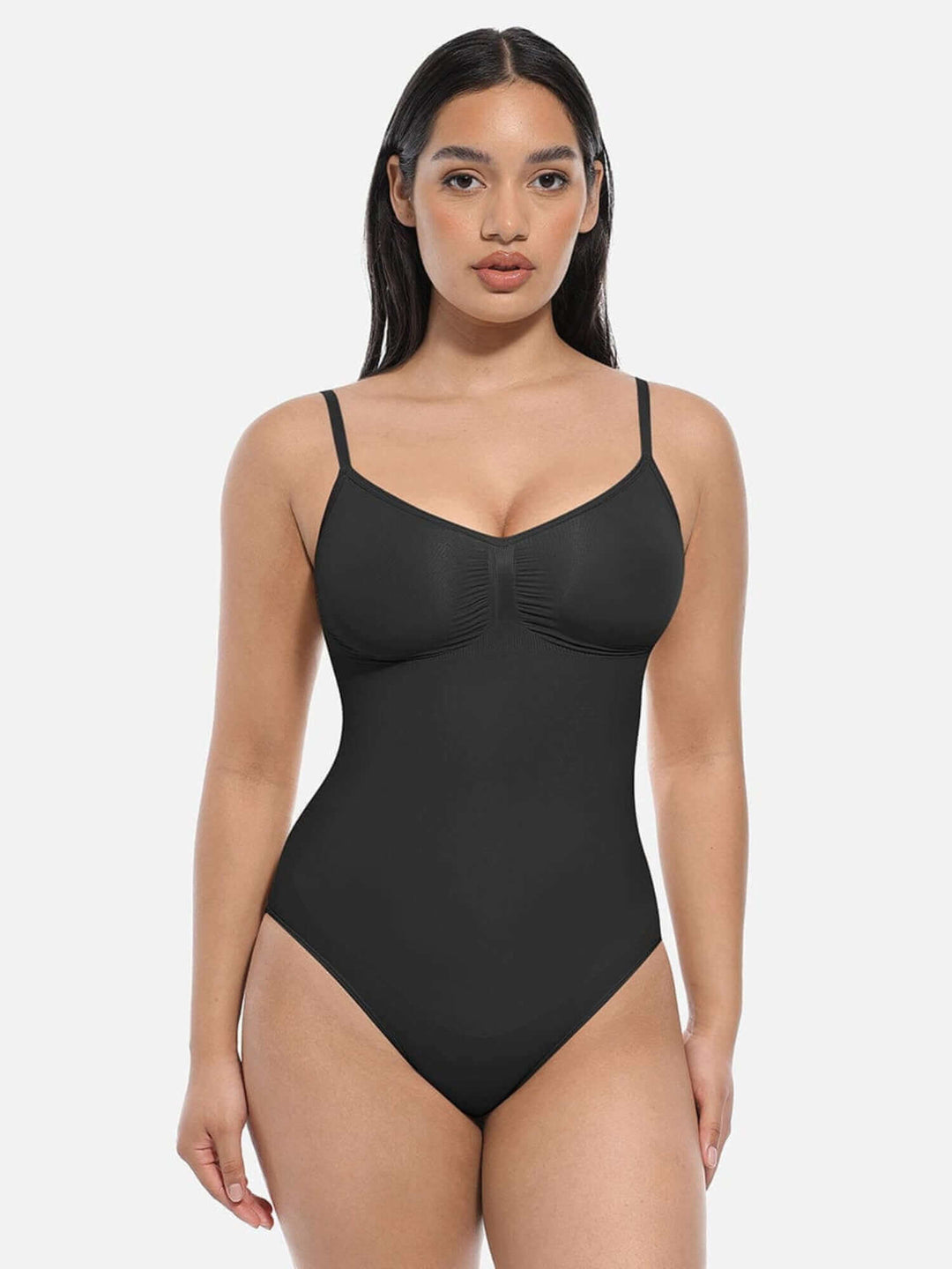 Model wearing a black seamless thong bodysuit with adjustable straps and a sleek design.
