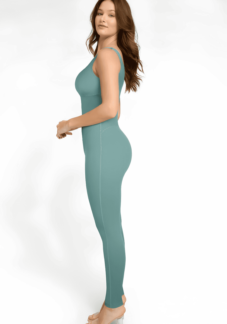 Woman wearing a sauna workout jumpsuit in teal, side view, fitted sports sauna jumpsuit for sweat-enhancing workouts