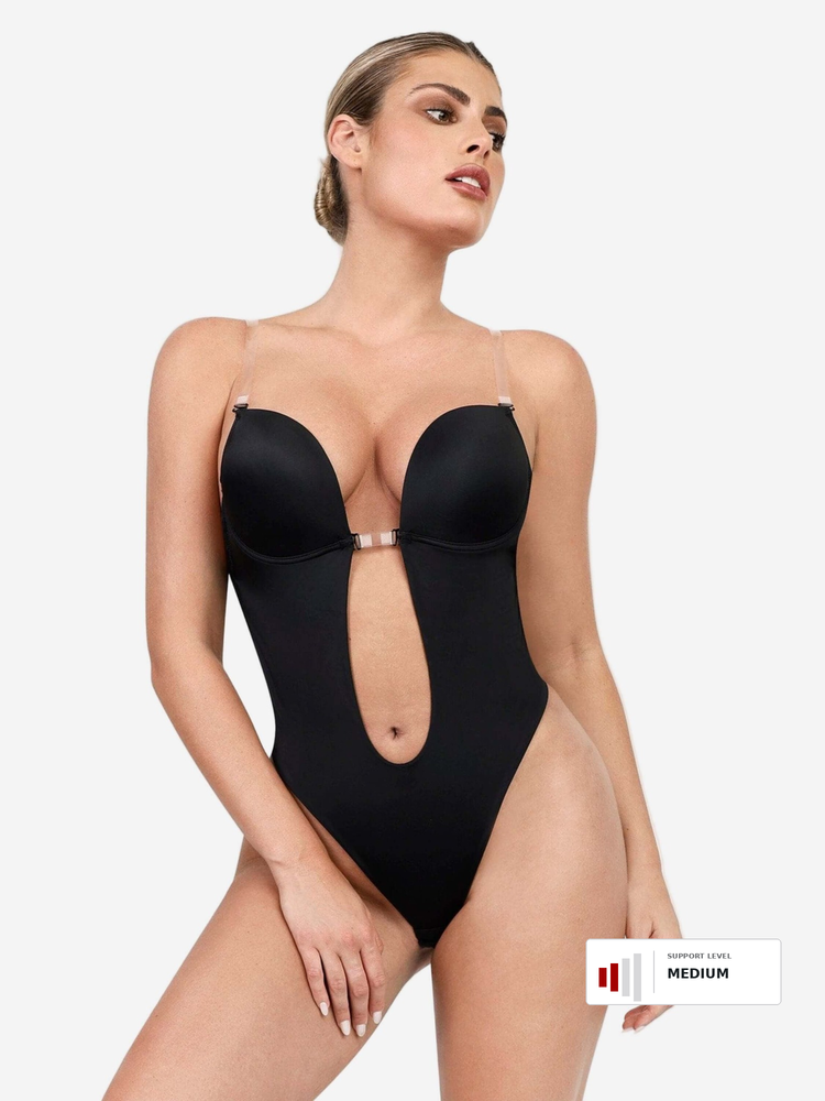 A woman modeling a black one-piece swimsuit with a plunging neckline, double bust cups, and a center cutout, shown against a light gray studio background. A small size label reading MEDIUM appears in the bottom right corner.