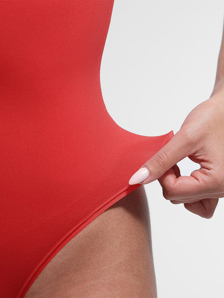 Red swimsuit with a hand holding it against a white background