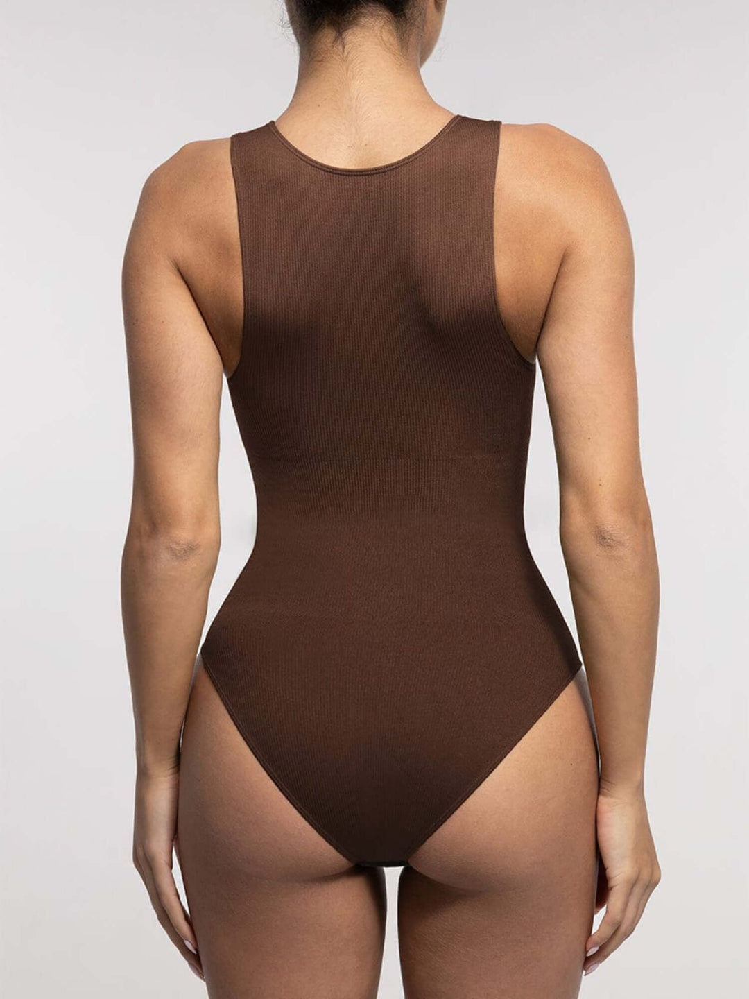 Brown swimsuit worn by a model on a plain background