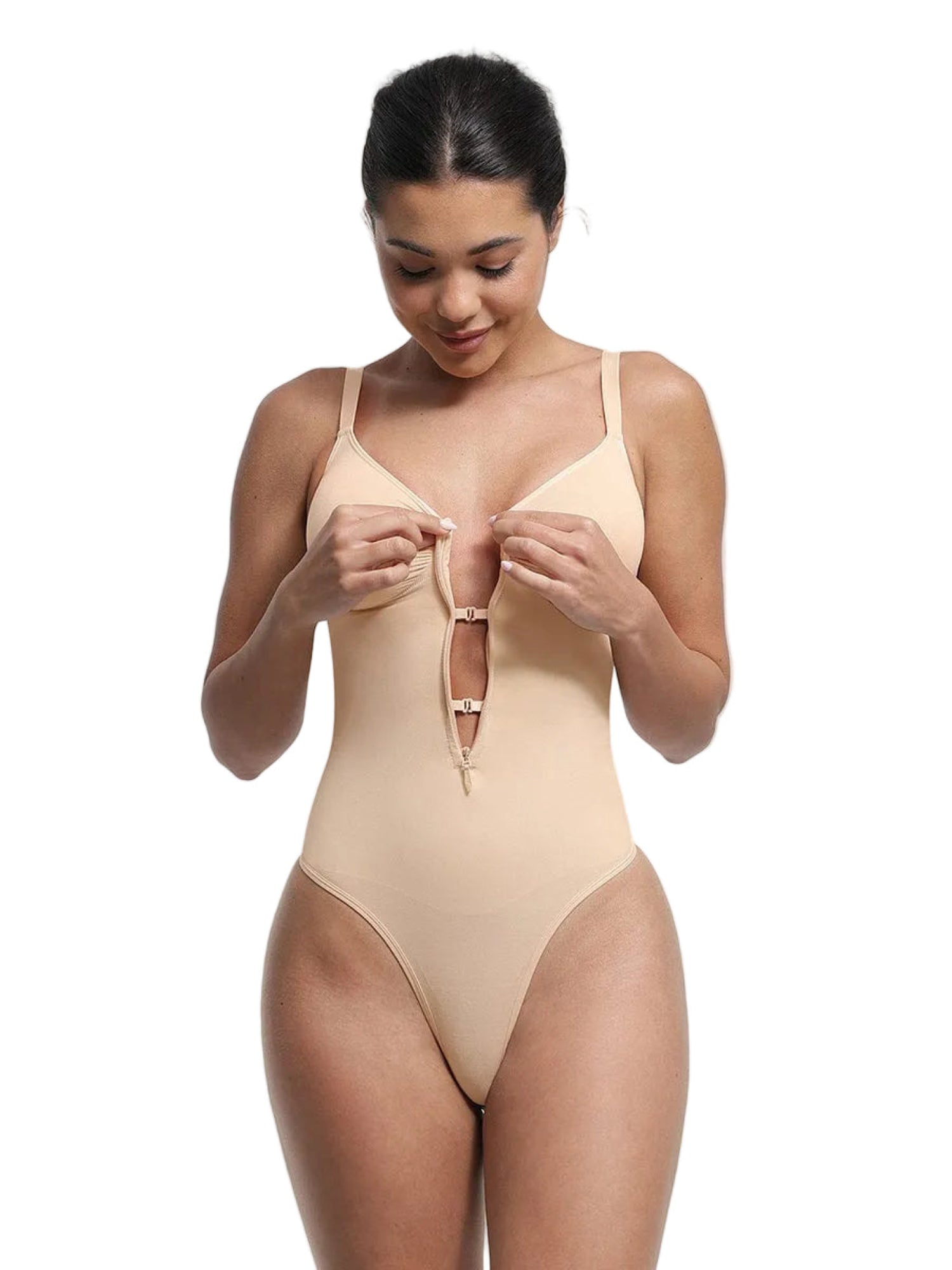 Woman wearing a beige bodysuit against a plain background