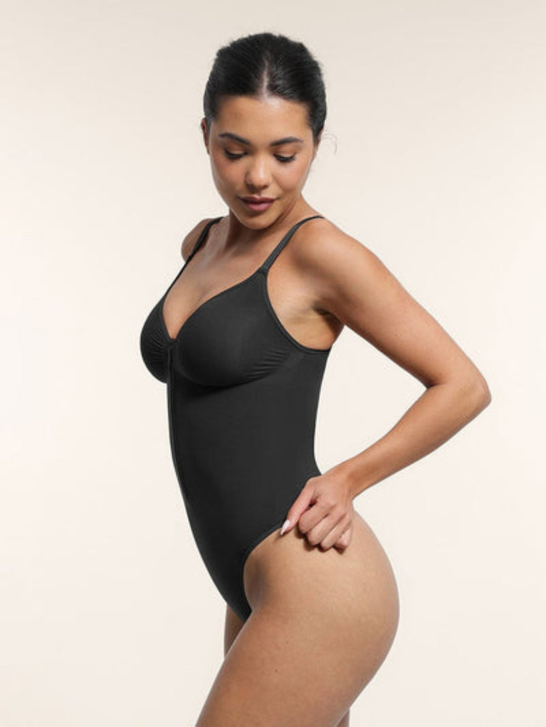 Woman wearing a black bodysuit against a plain background