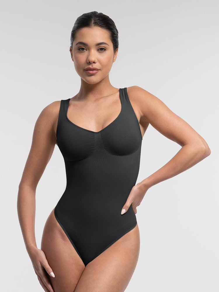Woman wearing a black swimsuit against a plain background