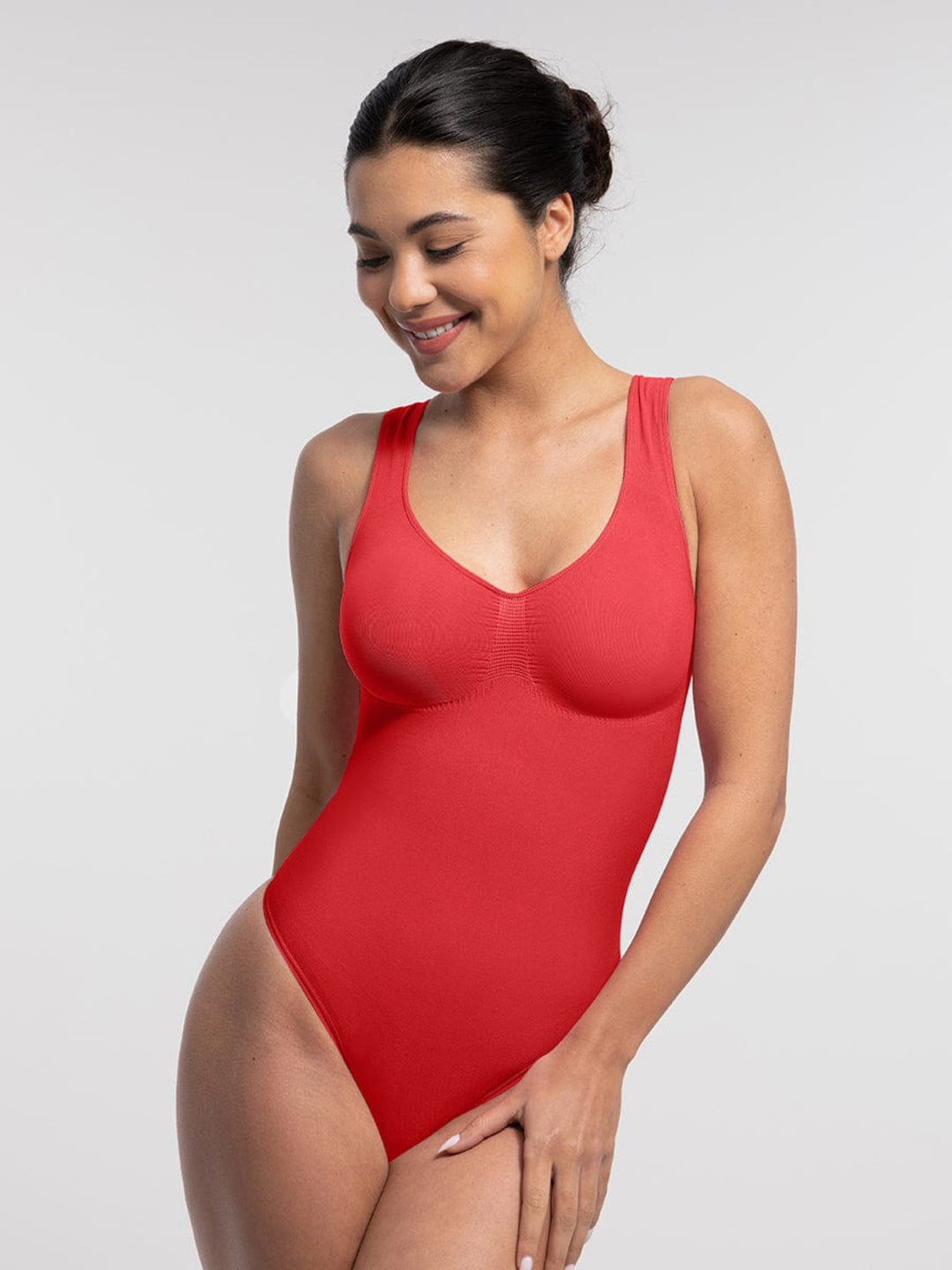 Woman wearing a red swimsuit against a plain background