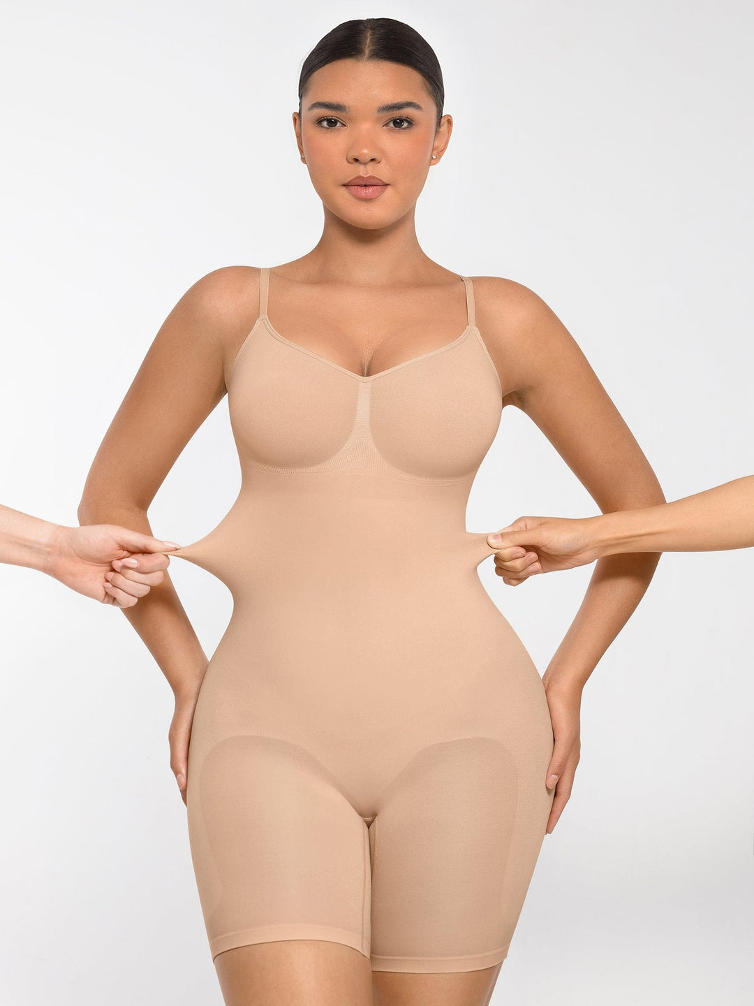 Woman wearing a beige shapewear garment against a white background